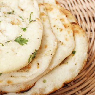 A wicker bread basket containing several vegan naan.