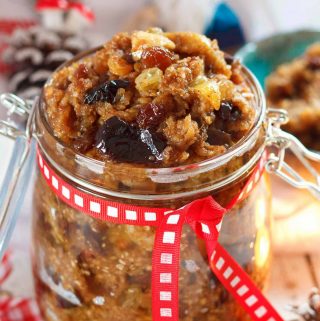 A jar of vegan mincemeat, with Christmas decorations in the background.