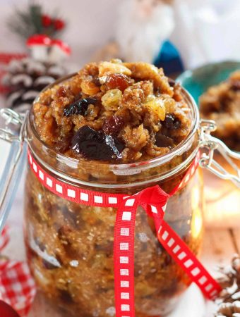 A jar of vegan mincemeat, with Christmas decorations in the background.