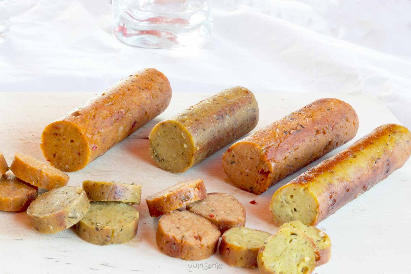 Four vegan sausages with a white background.