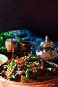 Moroccan vegetable tagine with a pot of tea and two glasses.
