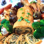 Roast stuffed seitan roulade on a platter with roast vegetables | yumsome.com