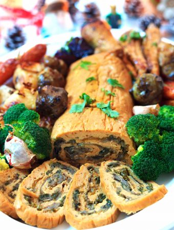 Roast stuffed seitan roulade on a platter with roast vegetables | yumsome.com