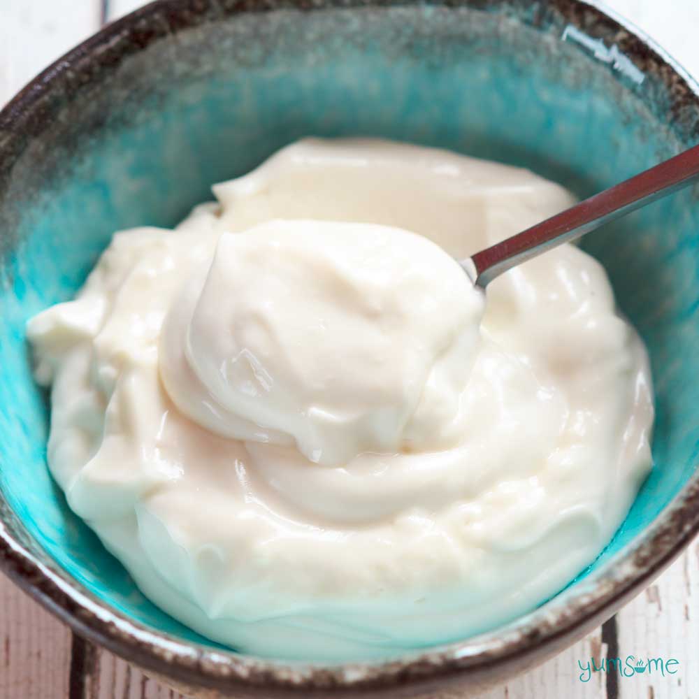 Tofu-free veganaise in a blue bowl, with a spoon.