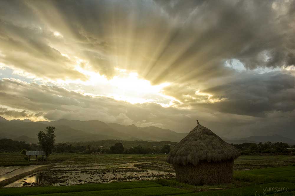 Sunset over a haystack in a field at Mae Hee, Thailand.