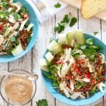 overhead view of two bowls of spicy buckwheat and mungbean salad on a table with some bread and tahini dressing | yumsome.com