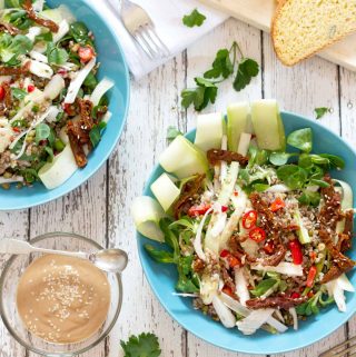 overhead view of two bowls of spicy buckwheat and mungbean salad on a table with some bread and tahini dressing | yumsome.com