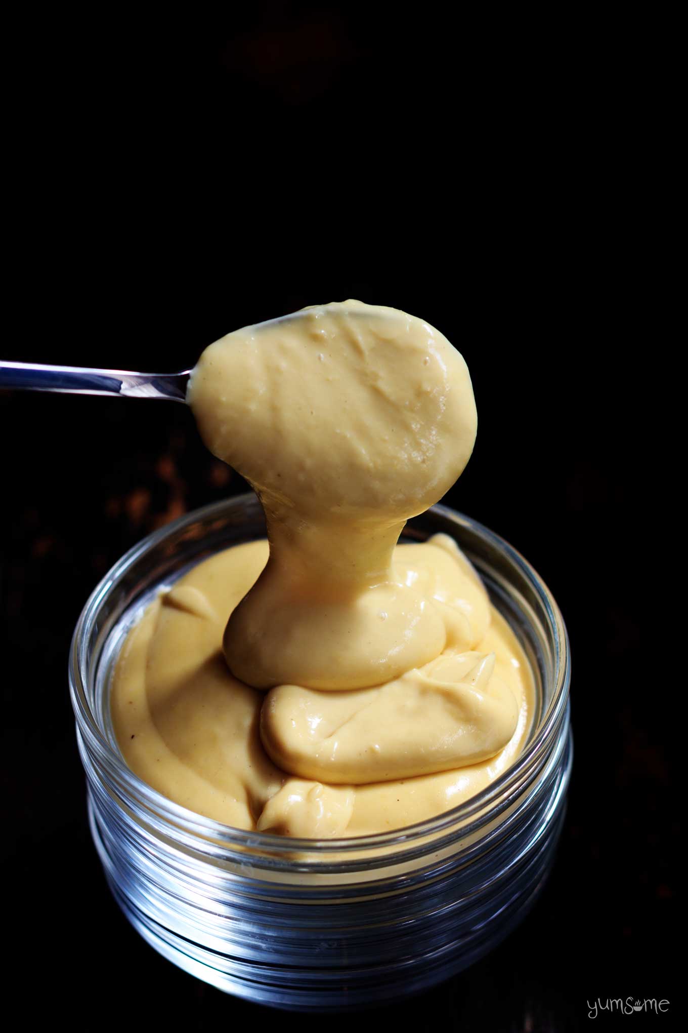 vegan cheese sauce dripping off a spoon | yumsome.com