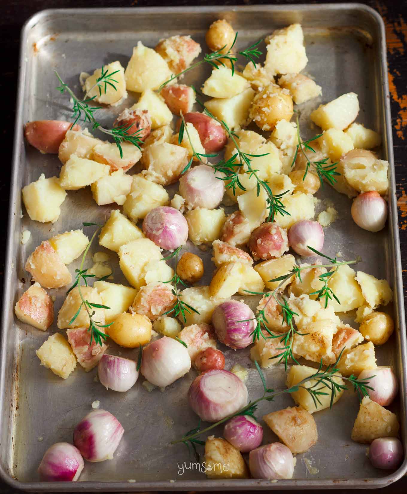 a tray of potatoes and onions ready to go into the oven | yumsome.com