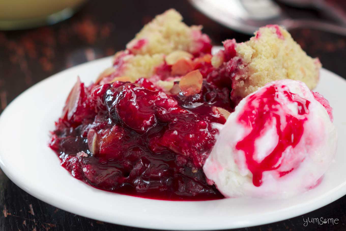 close up shot of some vegan spiced plum crumble with a scoop of ice cream | yumsome.com