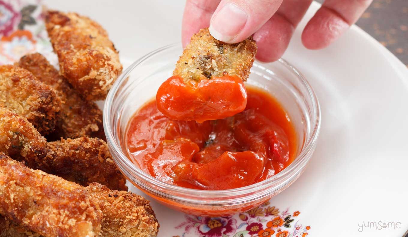 Close-up of cheesy pumpkin tots dipped in salsa.