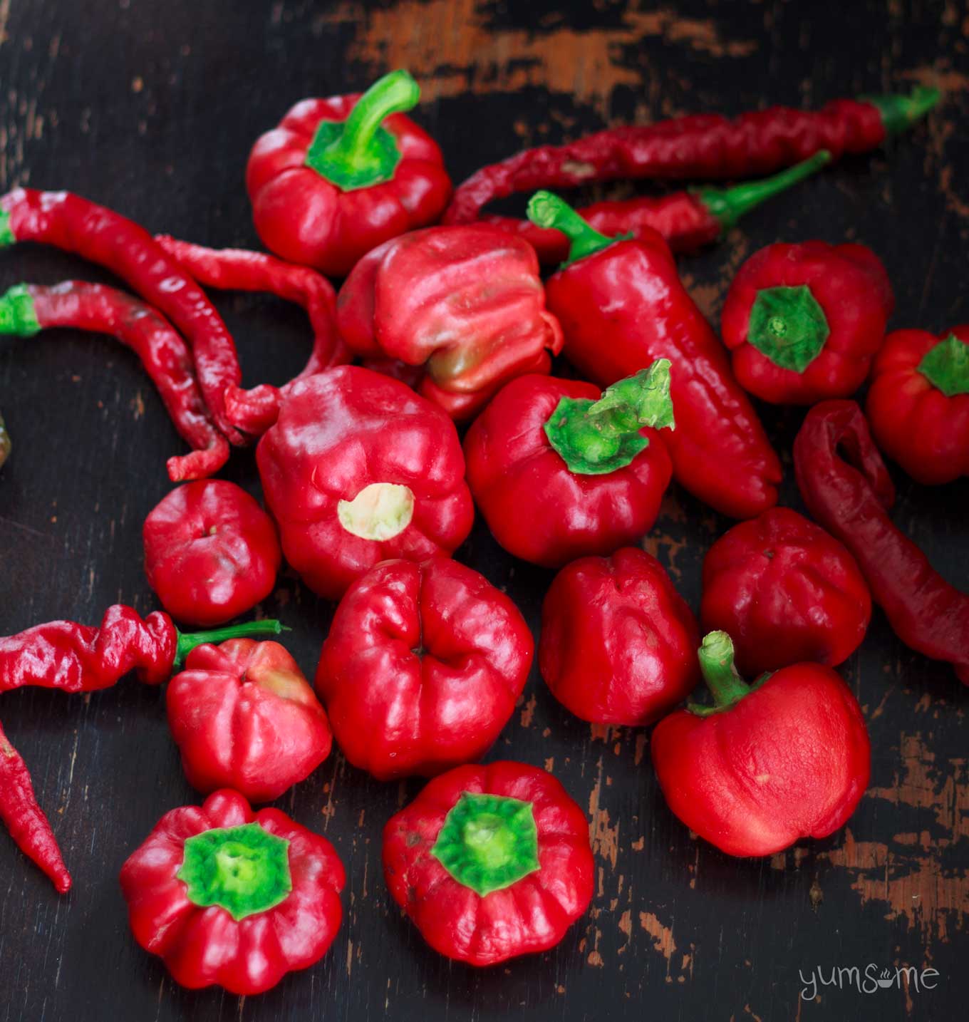 Romanian red peppers and chillies on a black table.