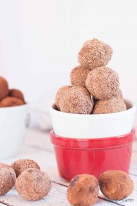 A stack of vegan raspberry chocolate truffles in a red and white bowl.