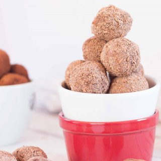 A stack of vegan raspberry chocolate truffles in a red and white bowl.