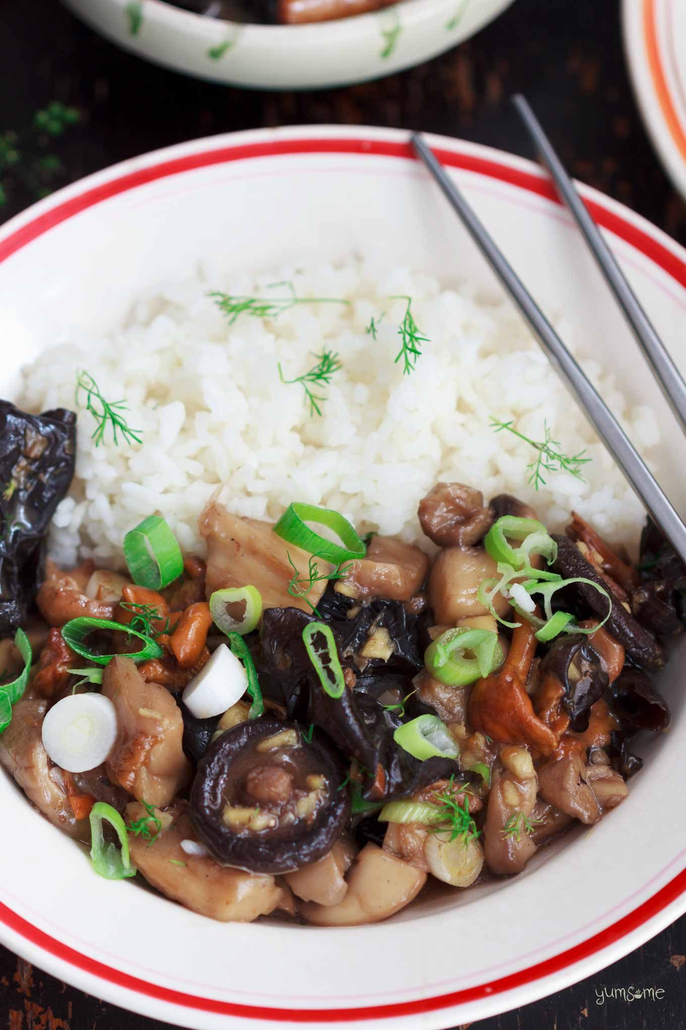 Asian-style mushrooms with ginger and rice in a white bowl, with silver chopsticks.