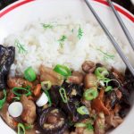 Asian-style mushrooms with ginger and rice in a white bowl, with silver chopsticks.