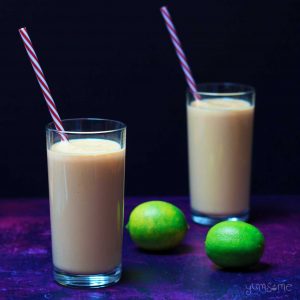 Two limes and two glasses of vegan mango lassi.