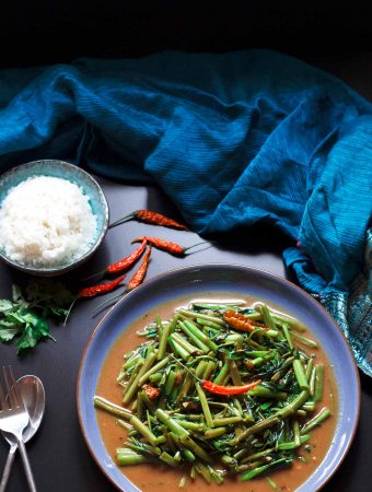 Overhead shot of a plate of vegan vegan Thai stir-fried morning glory.