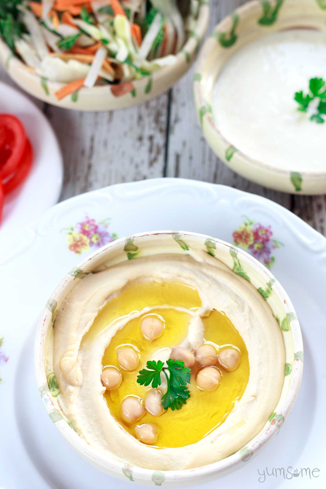 Chickpeas and olive oil in a bowl of perfectly smooth and creamy hummus.