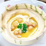 closeup of a dish of perfectly smooth and creamy hummus | yumsome.com