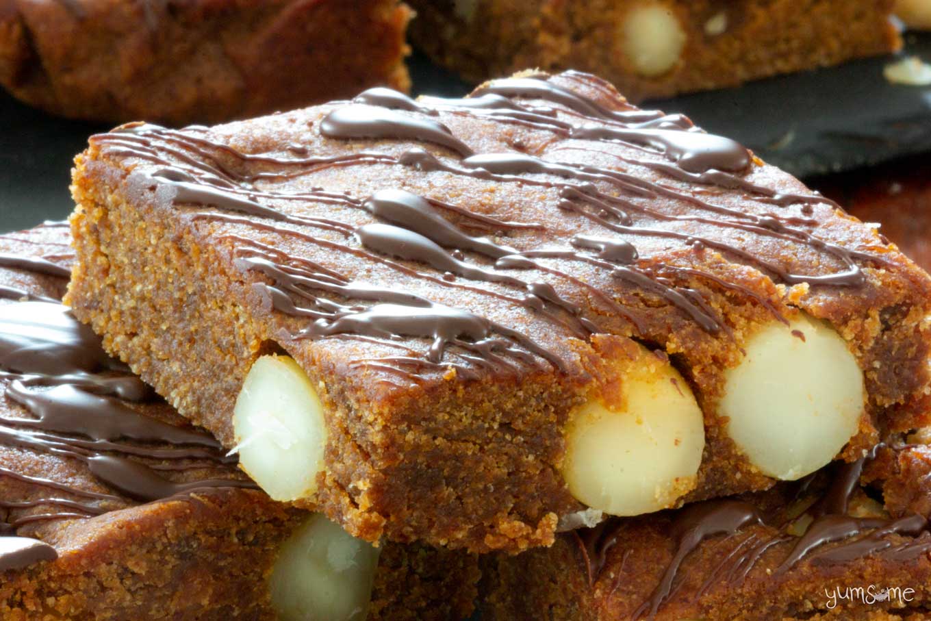 A chocolate-topped vegan cookie butter blondie, showing macadamias inside.