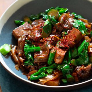 A black dish of phad si io on a blue napkin.