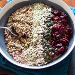 Vegan fruity buckwheat and hemp porridge in a black bowl on a blue napkin.