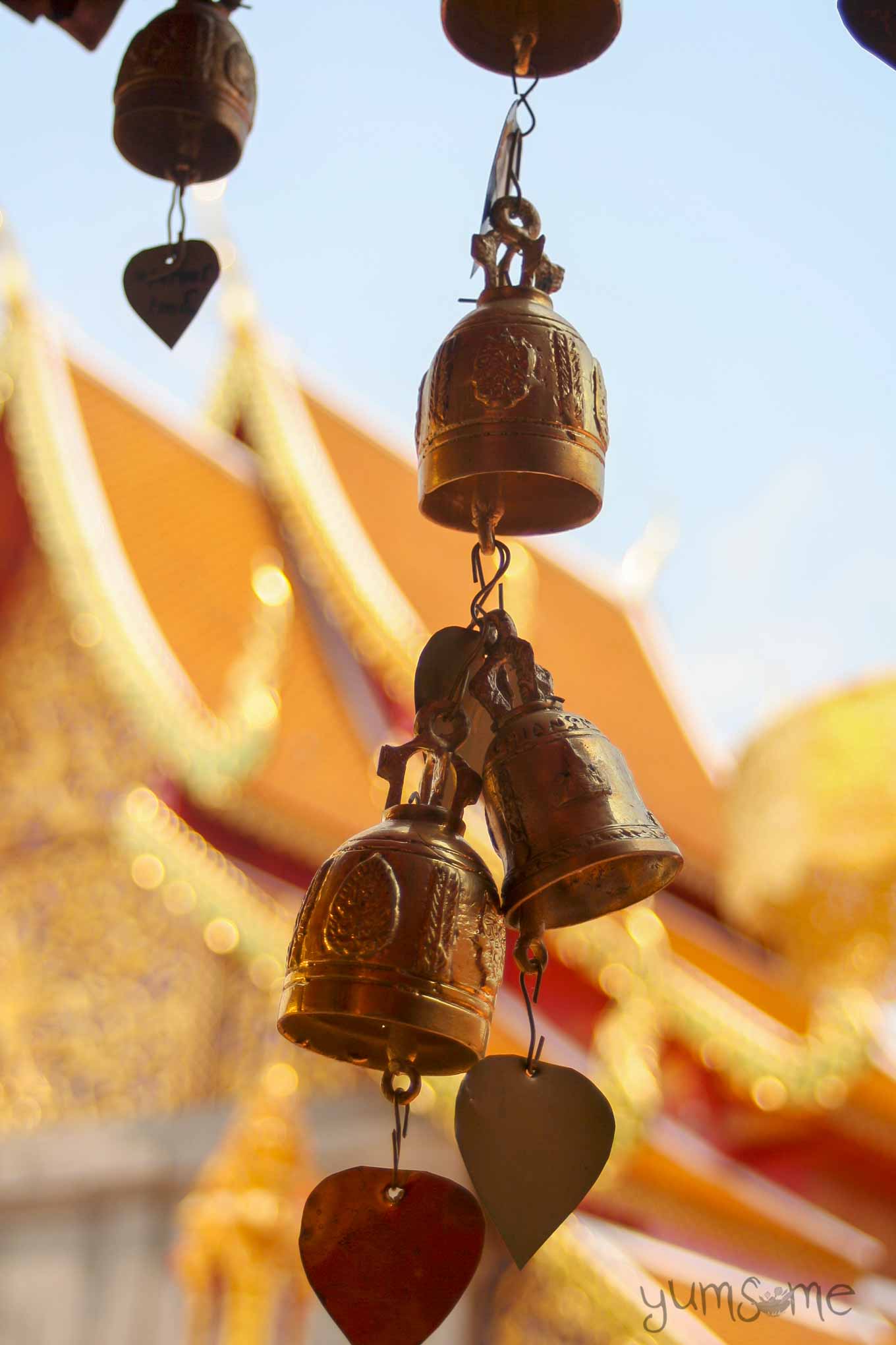 Small brass bells with two metal hearts hanging from the bottom.