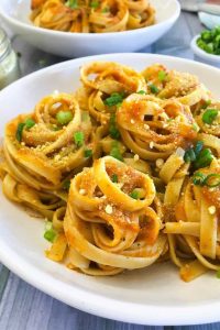 Nests of pumpkin pasta on a white plate.