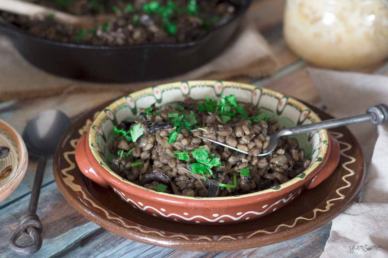 Czech mushroom and barley risotto in a rustic bowl with a rustic fork.