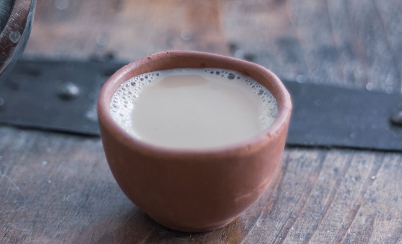 A small kulhar of masala chai on a wooden table.