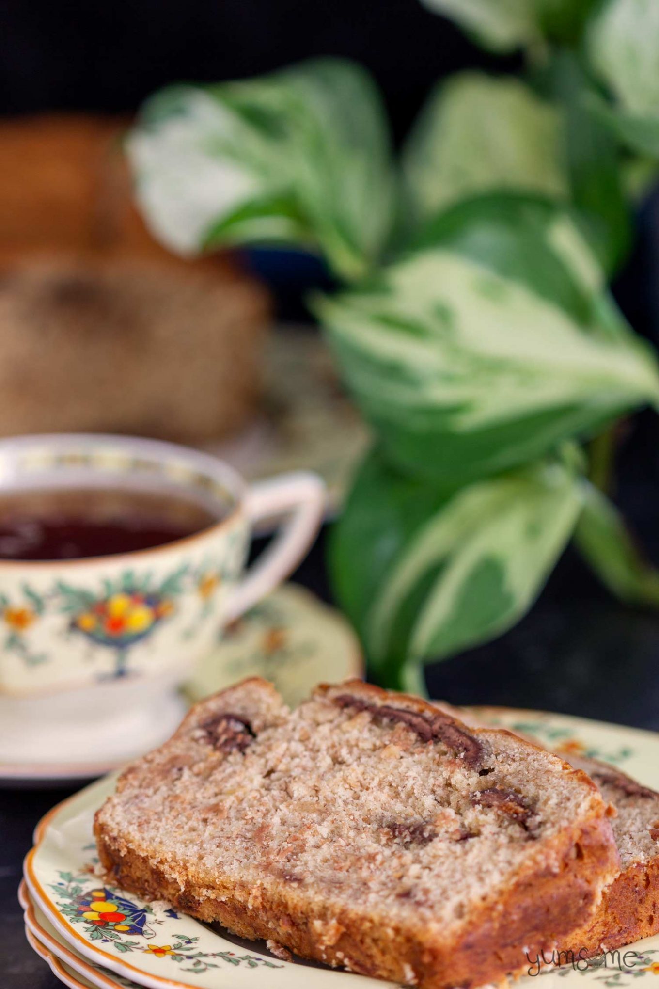 A cup of tea and a slice of chocolate chip banana bread.