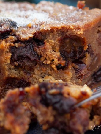 Close-up of a bite taken out of a piece of festive bread pudding.